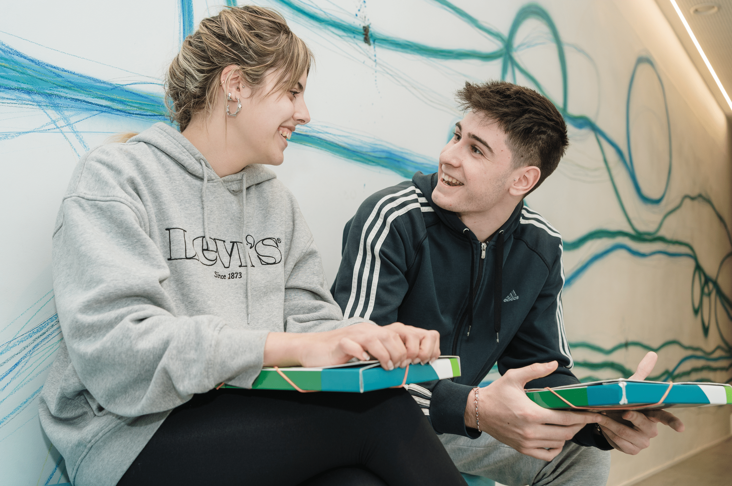 “Jóvenes adultos conversando antes de su curso de inglés para adultos en Camden Zaragoza.”